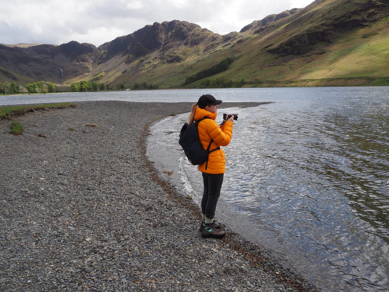 Photo of Sian Steel holding a camera at the edge of a lake
